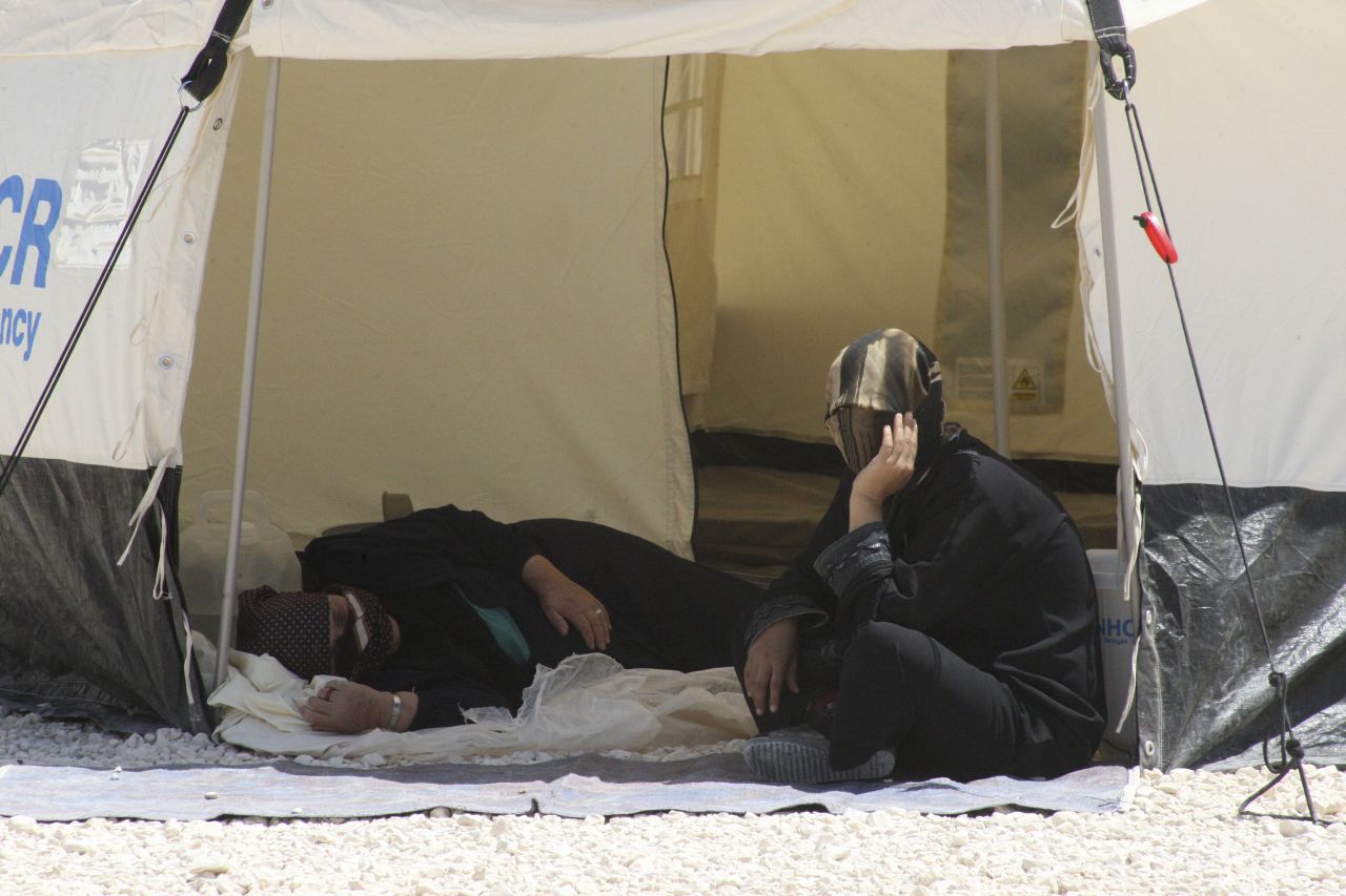 Syrian refugees look out from their tent.