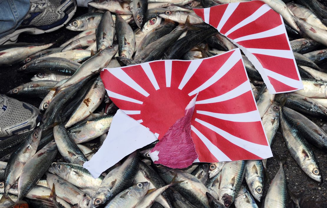 A torn apart Japanese 'Rising Sun' flag is placed on dead fish during a demonstration in Taipei on September 14, 2010, over the disputed Senkaku/Diaoyu island chain.