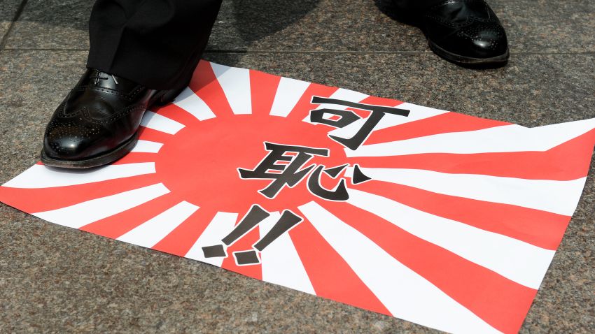 A Hong Kong activist steps on a paper replica of the Japanese imperial flag reading 'shameful' before burning it during a demonstration outside the building containing Japan's consulate in Hong Kong on August 24, 2012. About a dozen people handed a letter over to a representative from the consulate in protest about the ongoing dispute over a group of islands, known as the Senkakus in Japanese and the Diaoyus in Chinese. Japan on August 17 deported a group of pro-Beijing activists back to Hong Kong just 48 hours after some of the 14 had become the first non-Japanese to set foot on any part of the disputed archipelago since 2004.