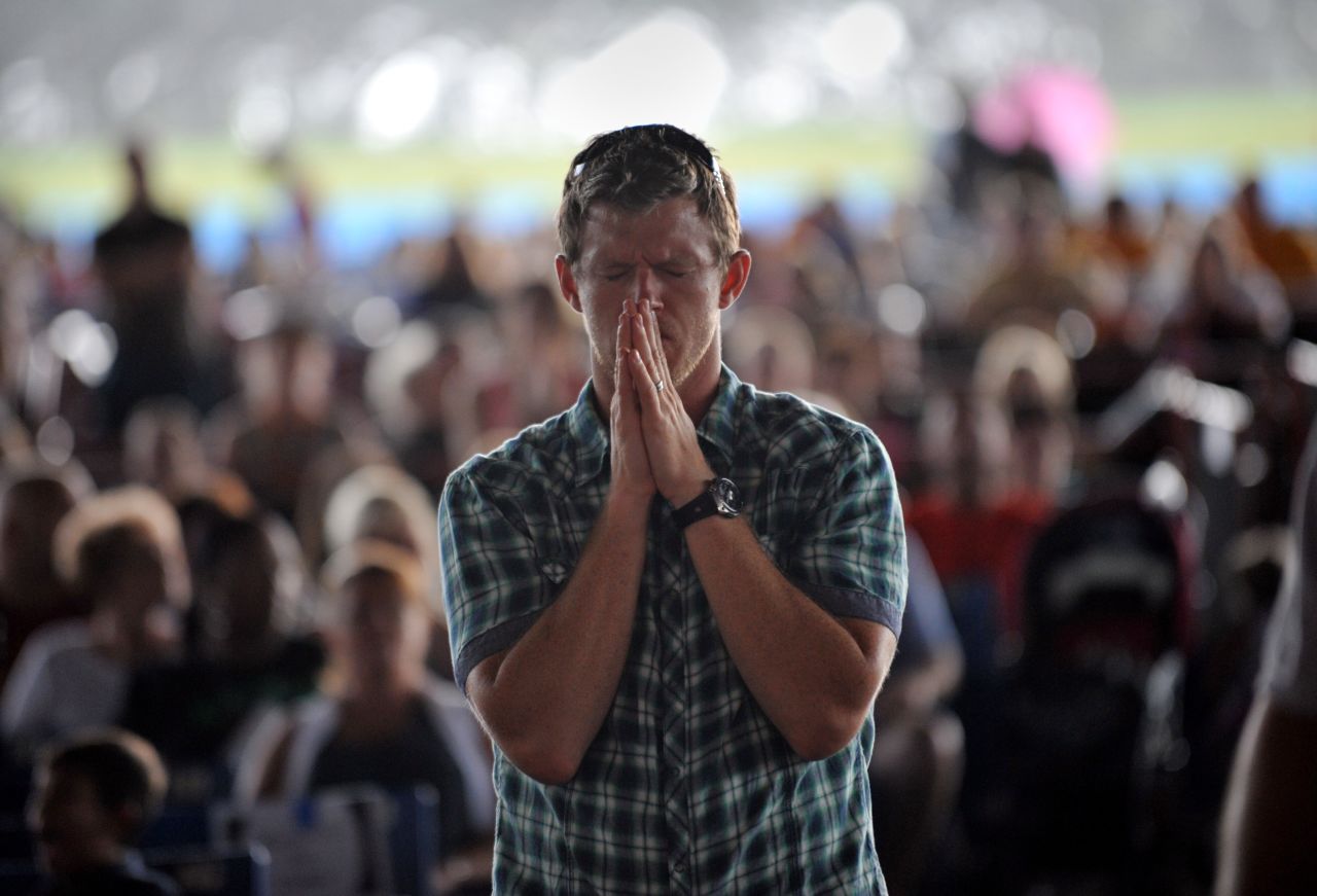 A man prays during a public prayer service at the Verizon Wireless Amphitheatre on Sunday, September 2, ahead of the convention.