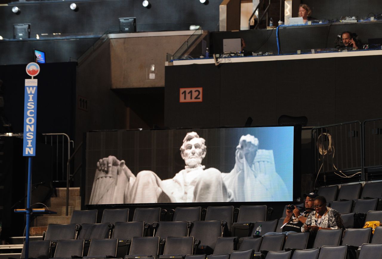 People in the Wisconsin delegation area sit in front of a digital image of the Lincoln Memorial hours before the start of the convention on Tuesday.