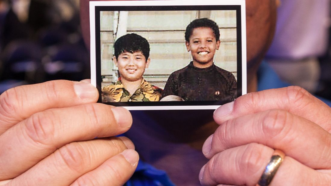 Dean Ando, a delegate from Washington, holds up a picture of himself and Barack Obama as fifth-graders at the Punahou School in Hawaii at the Democratic National Convention on Tuesday.