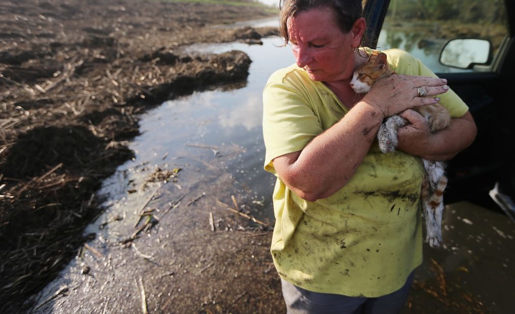 Melanie Martinez holds the family cat, now renamed Isaac, after salvaging items from her family's flooded home in Braithwaite on Monday, September 3. Martinez, along with her husband and her mother, was forced to ride out the storm in their Plaquemines Parish home when their car broke down. 