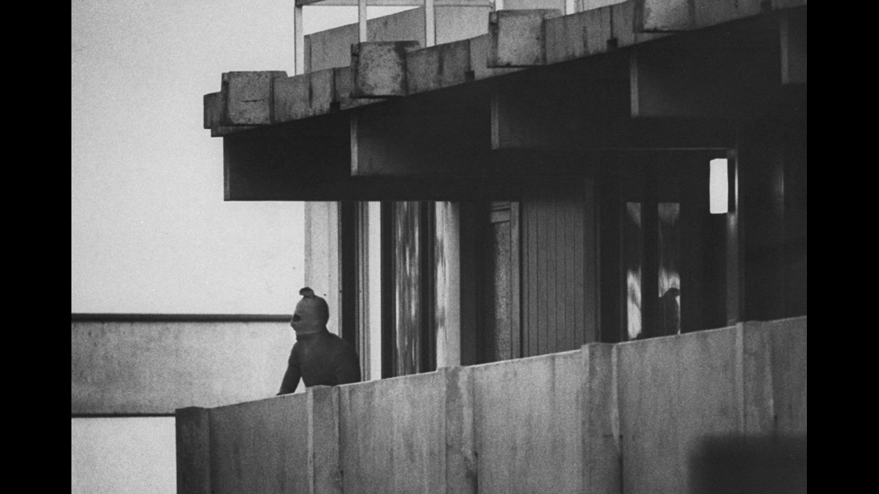 A Black September terrorist looks from the balcony of an apartment where Israeli Olympic team members are held hostage, Munich, September 1972.
