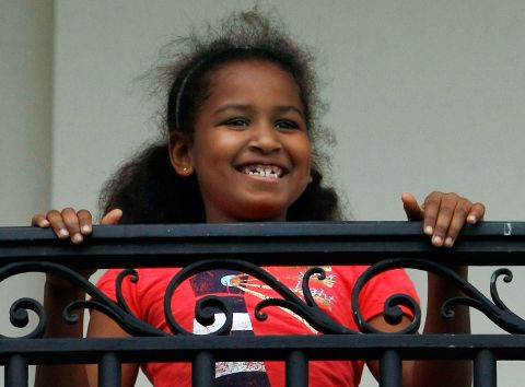 Sasha watches her dad from the Truman Balcony after he arrives on the South Lawn of the White House in May 2009.