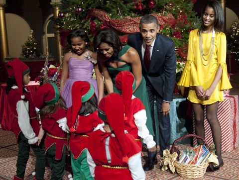 The first family greets children dressed as elves at a museum in Washington in December 2011. 