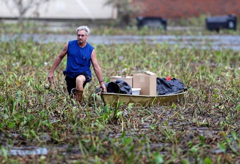 Richard Williams of the Braithwaite neighborhood in Plaquemines Parish, Louisiana, trudges through a debris field pulling a boat filled with things from his flooded home on Wednesday. Hurricane Isaac inundated his two-story home. 