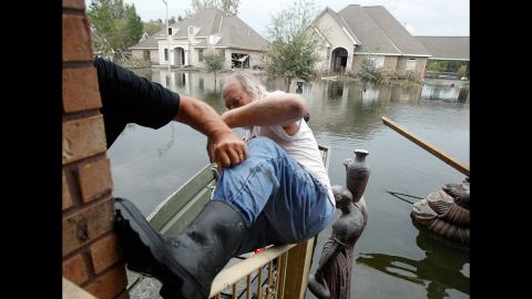 Fred Leslie is helped into a boat by Jesse Shaffer after he and his half-brother made their way to the house to retrieve items on Wednesday. The Braithwaite neighborhood is still under four feet of water eight days after Hurricane Isaac hit.