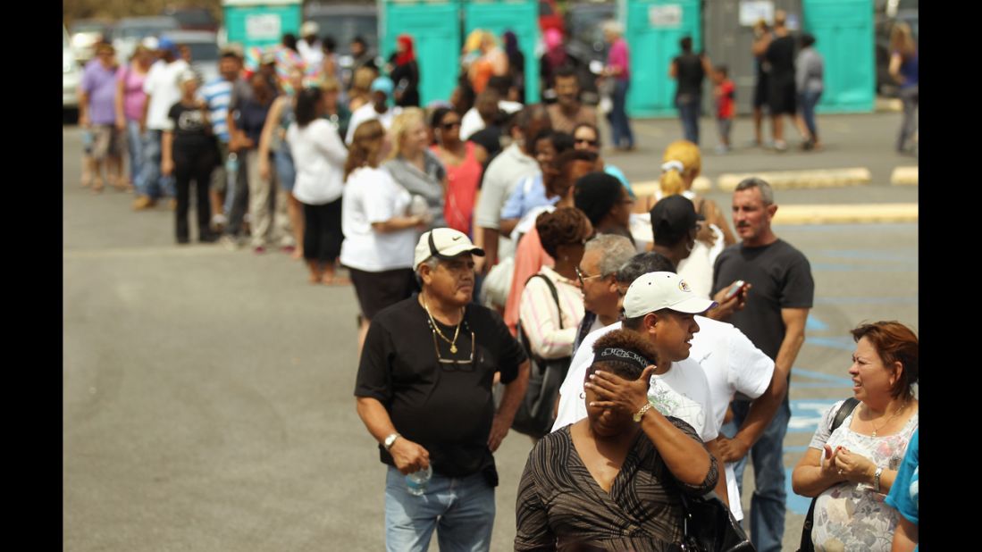 Residents wait in line to apply for disaster food assistance on Wednesday in Westwego, Louisiana.