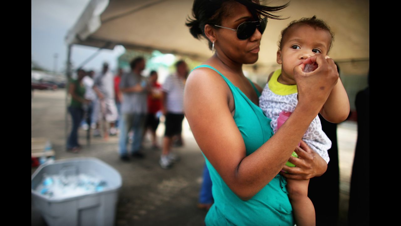 Ruth Bernard feeds ice to Micah Faciane to stay cool as they wait in line to apply for disaster food assistance on Wednesday in Westwego, Louisiana. Hundreds affected by Hurricane Isaac waited hours in the heat to apply for the Disaster Supplemental Nutrition Assistance Program.