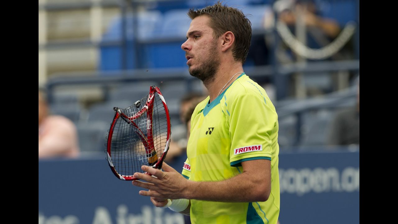 Wawrinka carries his broken racquet off the court during his match on Wednesday against Djokovic.