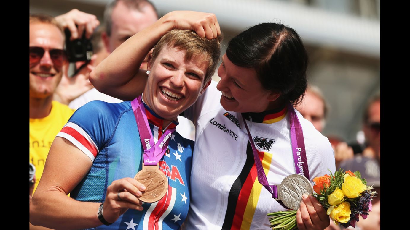 Bronze medalist Allison Jones, left, of the USA celebrates with silver medalist Denise Schindler of Germany after the women's individual C1-3 road race on Thursday.