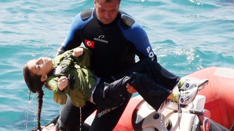  A diver carries a young girl who was rescued after a boat capsized Thursday in the Aegean Sea off western Turkey.