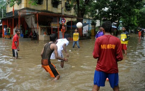 Indian residents play ball on a flooded street during heavy rains in Mumbai on August 27, 2012. The monsoon rains across the country have been more than 20% below average, sparking fears of drought among farmers who remember vividly the failure of 2009, when India suffered its worst drought in nearly four decades. 