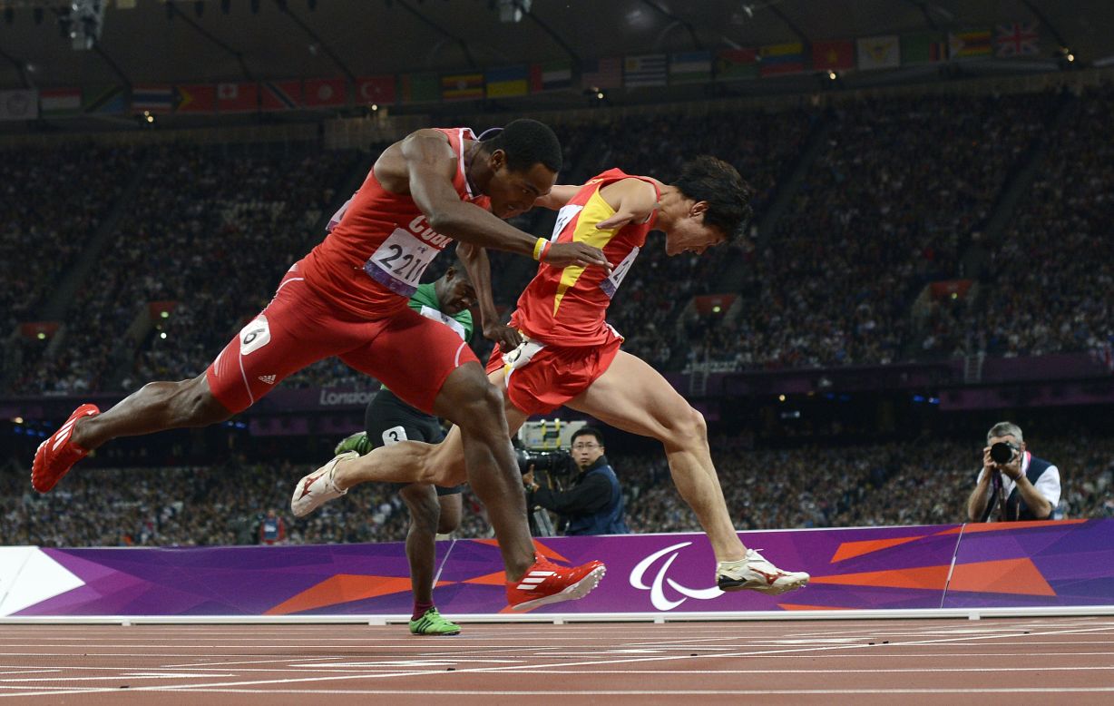 China's Zhao Xu, right, dips for the finish line, just ahead of Cuba's Raciel Gonzalez Isidoria to win the men's 100-meter T46 final on Thursday, September 6.