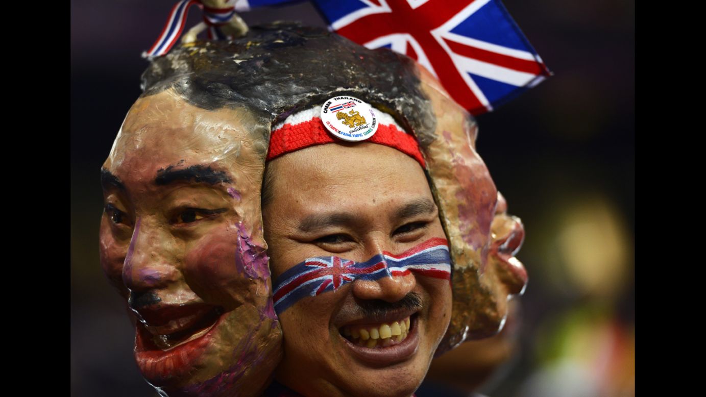 A spectator from Thailand wears masks as he watches Thursday's action at Olympic Stadium.