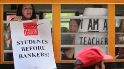 Chicago teachers display protest signs from inside a school bus as they leave a demonstration outside the Chicago Board of Education building on June 22, 2011.  