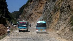 Two buses make their way across a road full of fallen rocks after a series of earthquakes, one of them measuring magnitude 5.7, hit the area near Zhaotong municipality at the border of southwest China's Yunnan and Guizhou province on September 7, 2012. The US Geological Survey put the magnitude of the largest quake at 5.6 and said it struck at a depth of 10 kilometres, with the office of China Earthquake Administration announcing that around 20 persons were injured and six had died. CHINA OUT AFP PHOTO (Photo credit should read STR/AFP/GettyImages) 