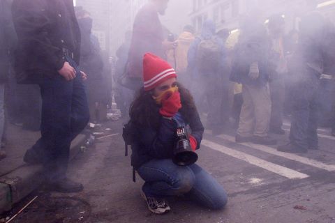 <strong>1999: </strong>A demonstrator covers her mouth with a scarf to protect herself from tear gas after street clashes with riot police in downtown Seattle during WTO protests.