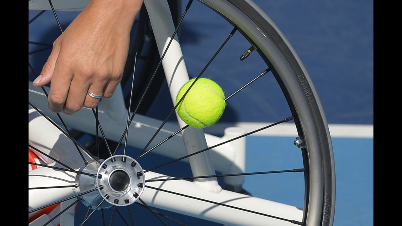 Netherlands' Esther Vergeer keeps a spare ball in the spokes of her wheelchair as she plays Netherlands' Aniek Van Koot in the women's singles wheelchair tennis final on Friday.