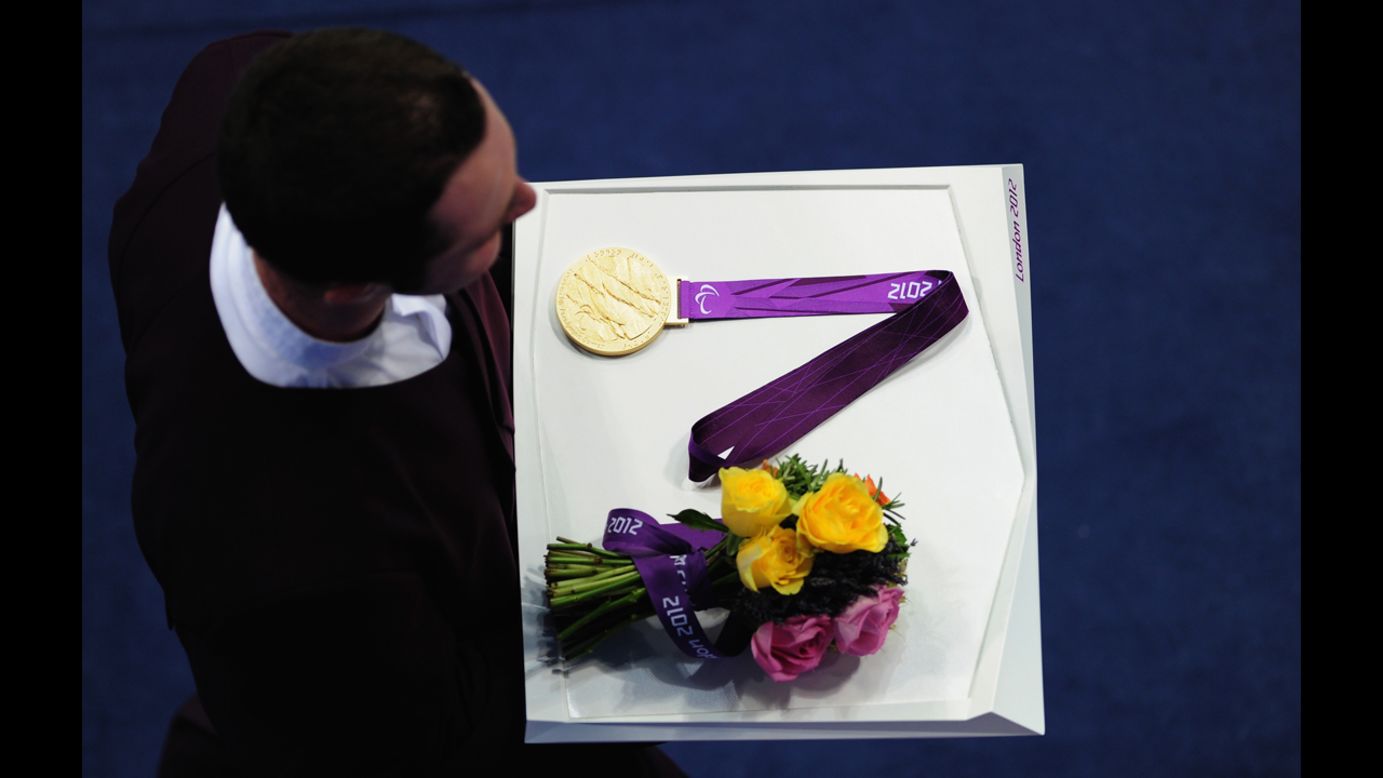 A medal bearer carries a medal and flowers on Friday.