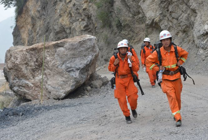 Rescuers walk past a landslide area after a series of earthquakes hit Yiliang County in China's Yunnan Province on Saturday, September 8. Two 5.6-magnitude quakes hit mountainous southwestern China, killing at least 80 people and forcing tens of thousands to leave damaged buildings, state media said.