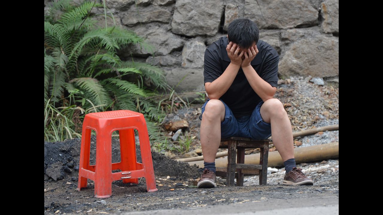 A man reacts as he sits outside his house on Saturday after a series of earthquakes. 