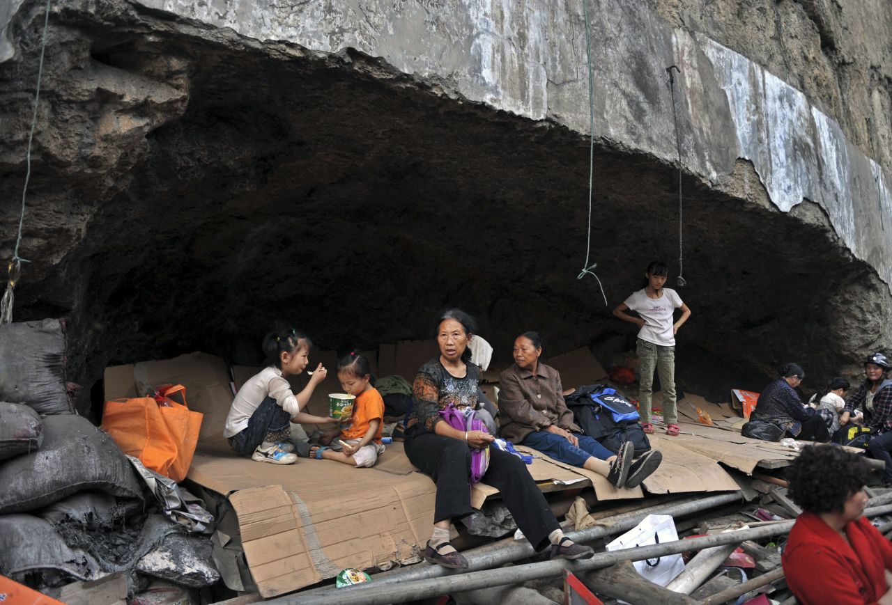  Residents rest in a stone cave, their temporary shelter, in Yiliang on Saturday. 