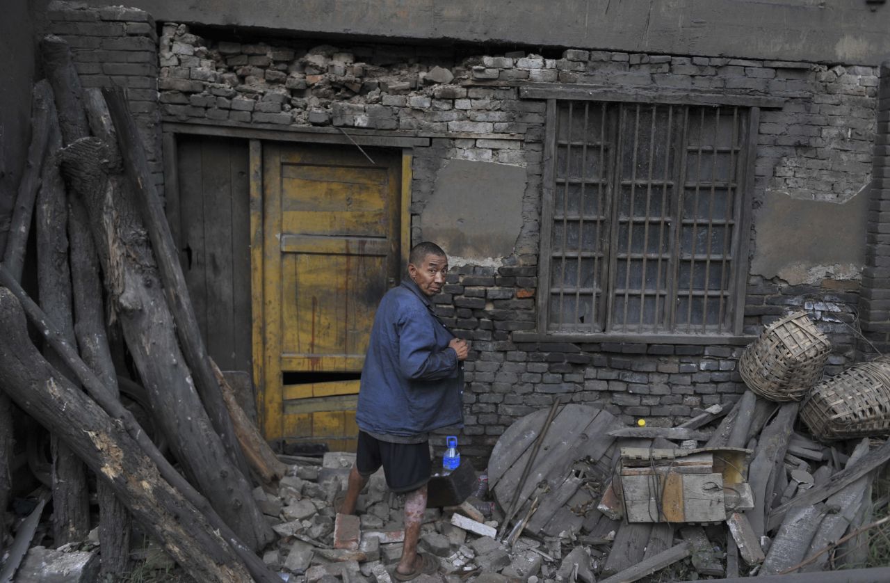 A resident returns to his damaged home  on Saturday, September 8, after staying out for a night following an earthquake in Yiliang, Yunnan province. 
