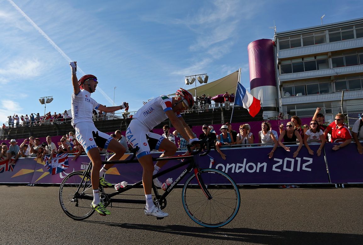 Ivano and Lucca Pizzi of Italy celebrate winning the men's individual B cycling road race on Saturday.