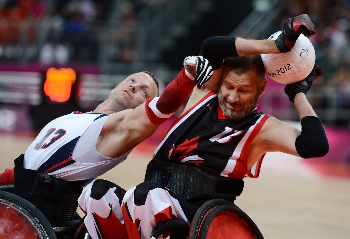 No. 13 Derrick Helton of the United States attempts to get the ball from No. 13 Jared Funk  of Canada during Saturday's mixed wheelchair rugby semifinal match between the U.S. and Canada.