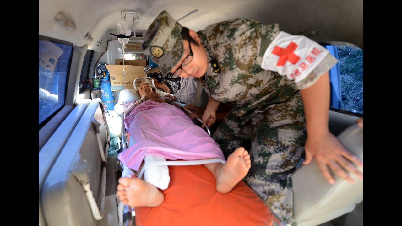 A woman is loaded into an ambulance Sunday after being injured in a landslide following a series of earthquakes.