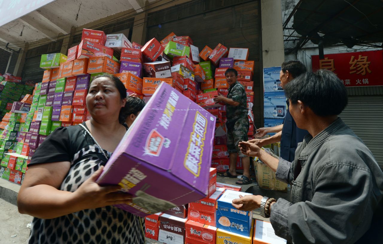 Residents receive food aid in Yiliang on Sunday. About 100,000 people have been evacuated and 100,000 others are in need of relocation, state media reported.