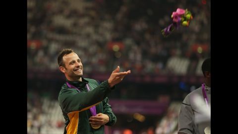 Gold medalist Oscar Pistorius of South Africa throws a bouquet of flowers on the podium during the medal ceremony for the men's 400-meter T44 final Saturday, September 8, at the 2012 Paralympic Games.