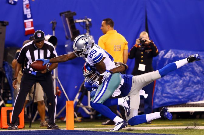 No. 85 Kevin Ogletree of the Dallas Cowboys drags No. 21 strong safety Kenny Phillips of the New York Giants into the end zone to score a touchdown in the third quarter on Wednesday.