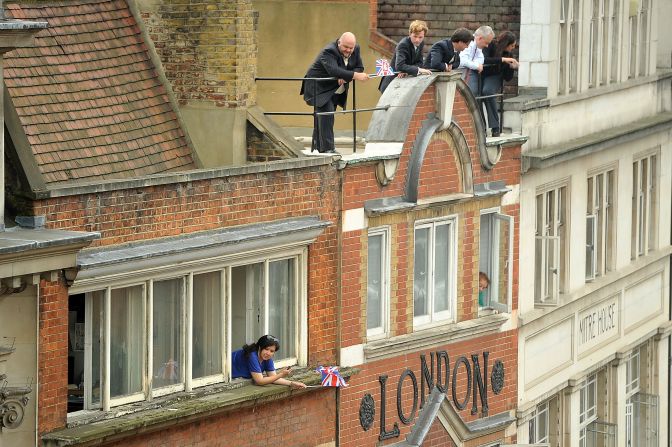 Spectators watch the Victory Parade as it passes by on Fleet Street, London.