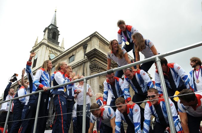 Members of the Olympics rowing team create a pyramid atop one of the floats.