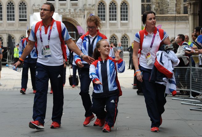 Swimmer Eleanor Simmonds, known as "Ellie", waves to the crowds as she walks along during the Victory Parade. Simmonds won two gold medals and a silver at the Paralympics.
