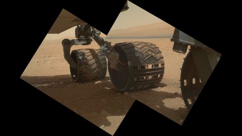 This view of the three left wheels of NASA's Mars rover Curiosity combines two images that were taken by the rover's Mars Hand Lens Imager on September 9, 2012, the 34th day of Curiosity's work on Mars. In the distance is the lower slope of "Mount Sharp."