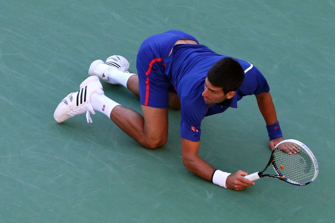 Novak Djokovic drops to the floor as he returns a shot on Monday.