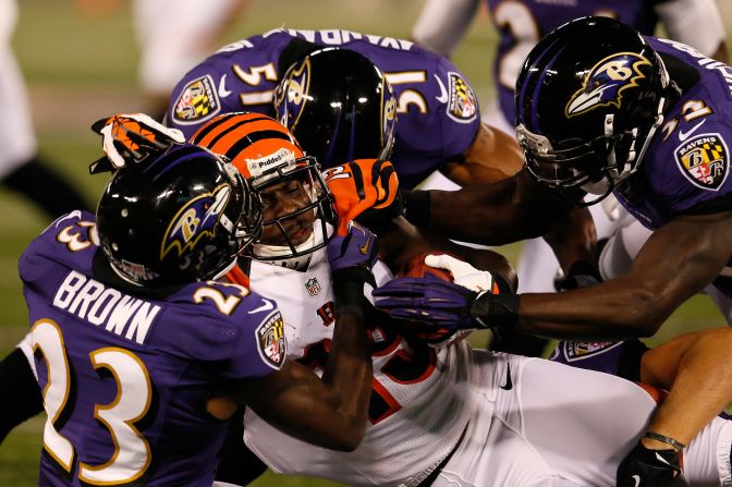 Wide receiver Brandon Tate of the Cincinnati Bengals is hit by defensive back Chykie Brown and linebacker Brendon Ayanbadejo of the Baltimore Ravens after a return in the first half on Monday, September 10.