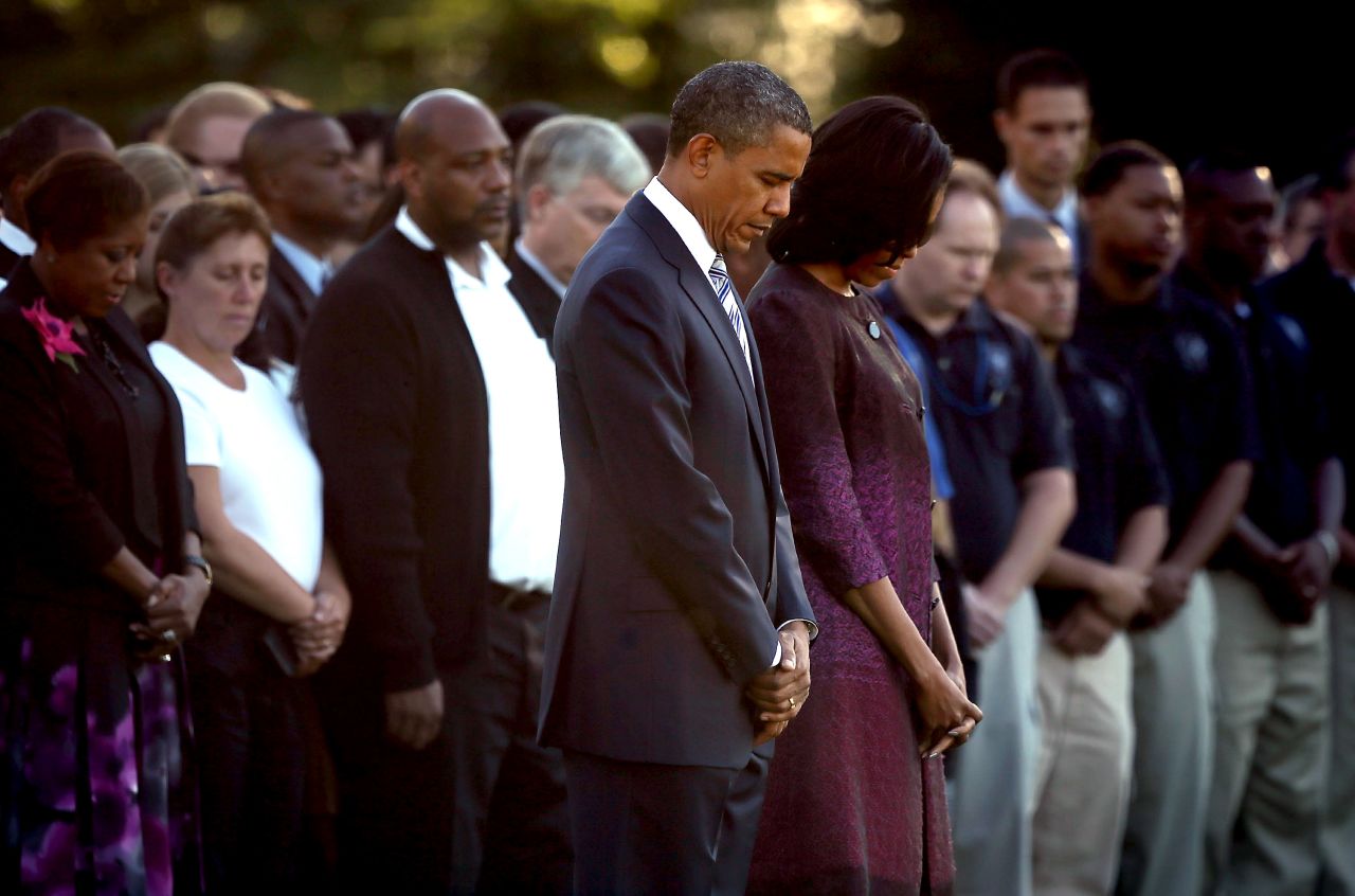 President Barack Obama and first lady Michelle Obama observe a moment of silence with White House staff on Monday.