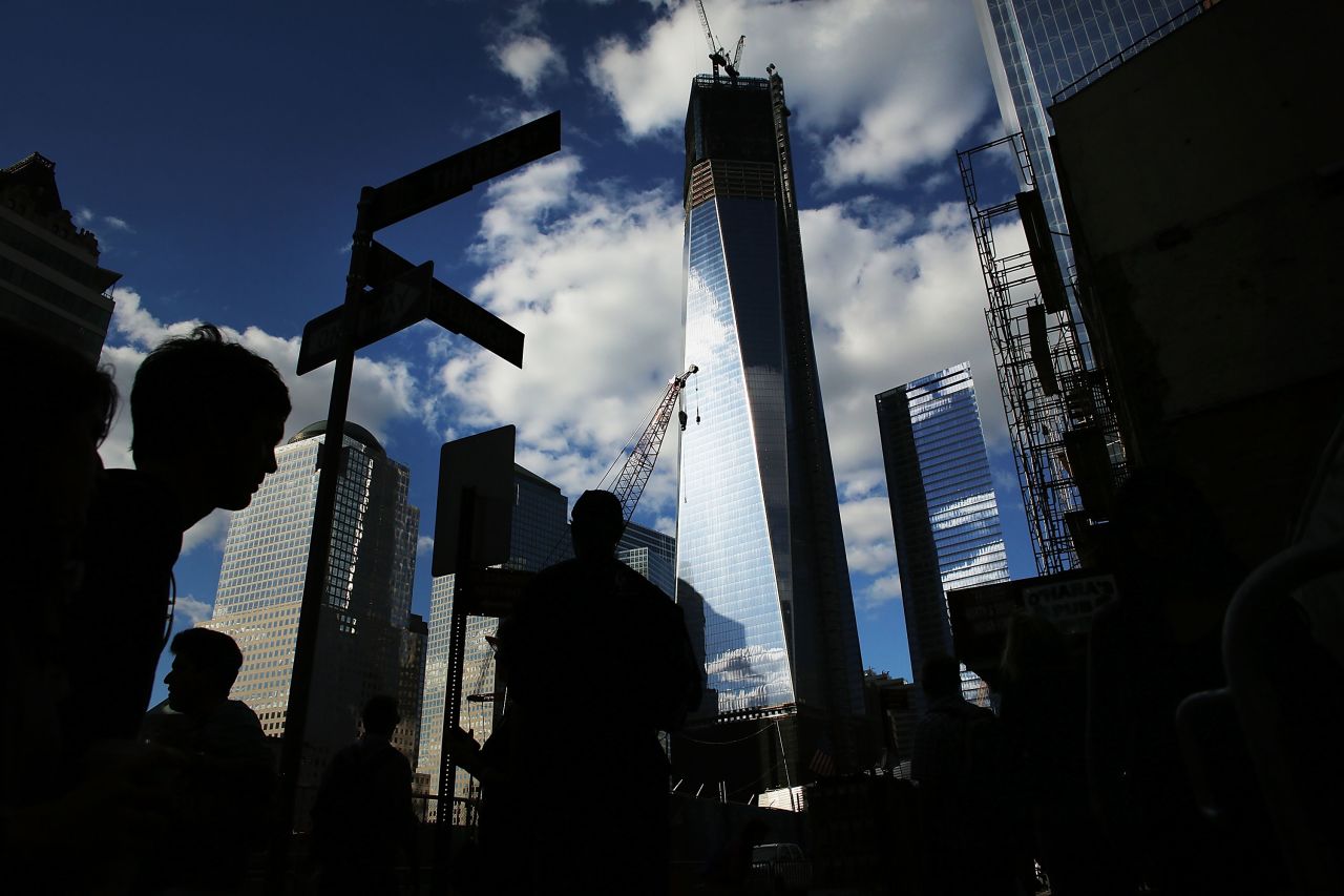 Pedestrians walk by One World Trade Center on the eve of the 11th anniversary of the September 11 terrorist attacks on September 10, 2012, in New York City.