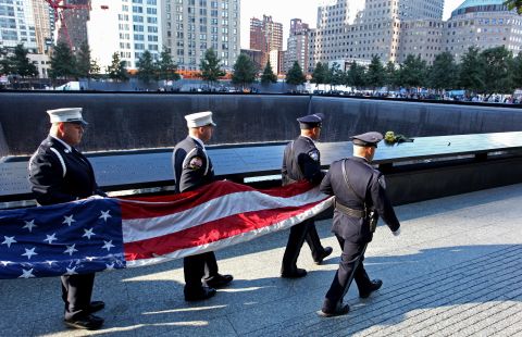 An honor guard carries an American flag Tuesday near the South Pool of the 9/11 Memorial.