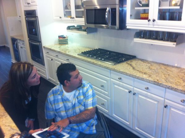 Dominguez explores the automated kitchen in his new 'smart' home with Danielle Tocco of Standard Pacific Homes. The home is controlled by an iPad, with which Dominguez can move cabinets and access the security system and air conditioning.