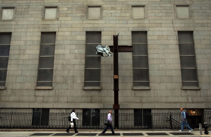 Pedestrians walk by the cross where it was mounted on Church Street in Lower Manhattan on September 11, 2008.