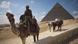 An Egyptian man waits for tourists to take them on camel rides at the Giza pyramids on the outskirts of Cairo on February 14, 2011.