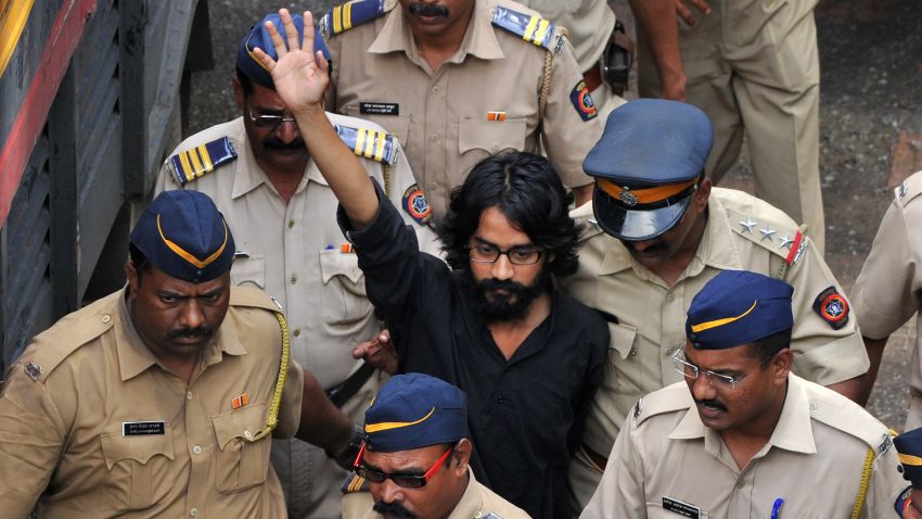 Indian cartoonist  Aseem Trivedi,  who has been arrested on sedition charges, raises his hand outside  the Metropolitan Magistrate court in Mumbai on Monday
