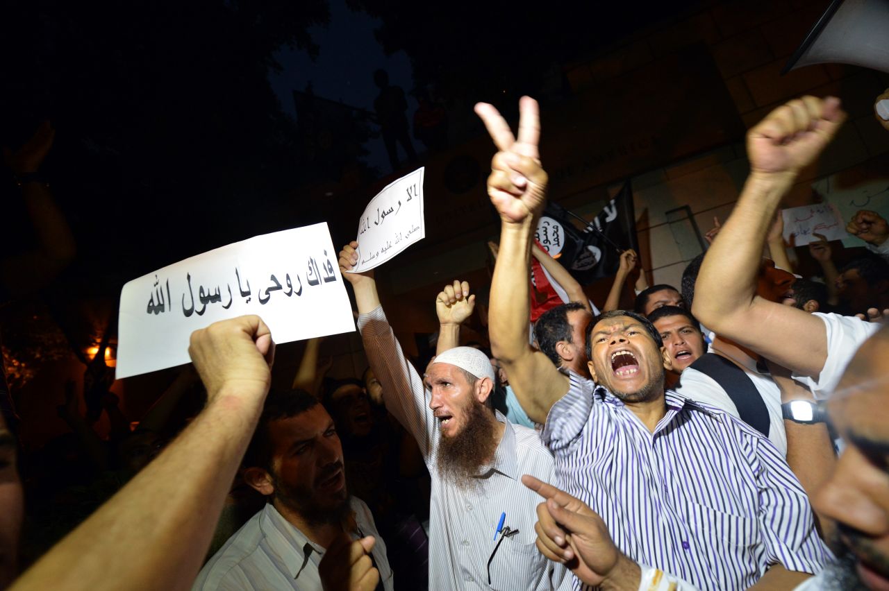 Egyptian riot police stand guard as protesters climb down from the wall.