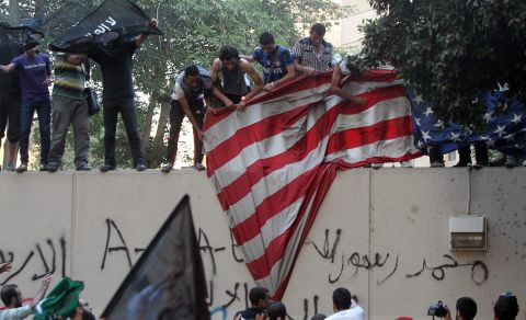 Protesters pull down a U.S. flag.